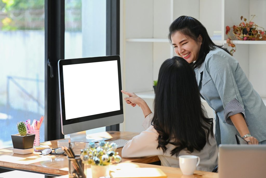 Two real estate agents using a real estate chat bot in their home office.