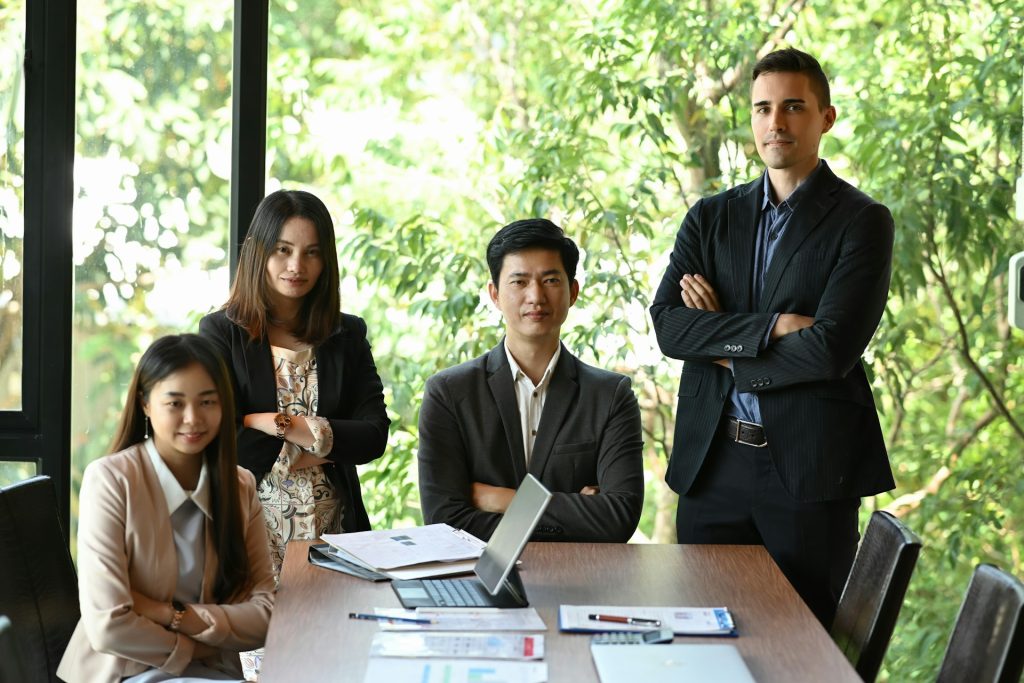 A group of small-scale real estate investors gathered around a table, discussing and asking questions