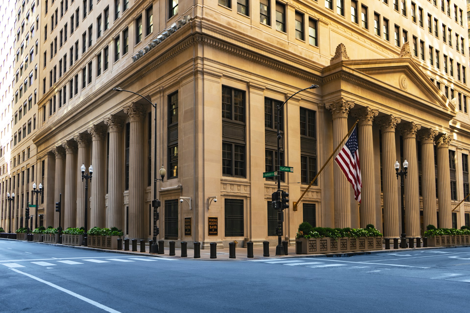 A modern office building with a bank sign, surrounded by other businesses and a bustling city street