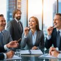 A group of male and female corporate landlords smoking cigars and laughing about the upcoming housing market crash they are creating.