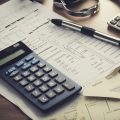 A rental property with a calculator and financial documents spread out on a table, surrounded by charts and graphs showing calculations of yield