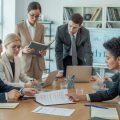 Business professionals reviewing commercial lease documents together in a bright office conference room.